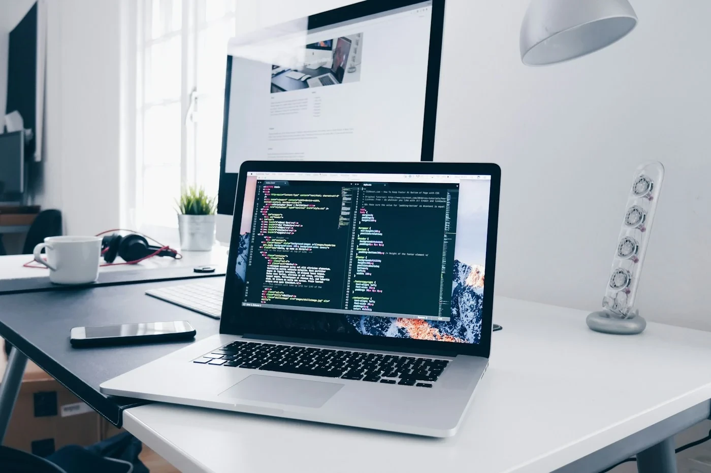 Entwicklungsarbeitsplatz mit geöffnetem Programmcode auf einem Laptop